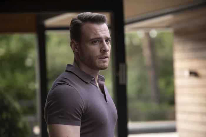 Kerem Bursin poartă un tricou închis la culoare, cu guler