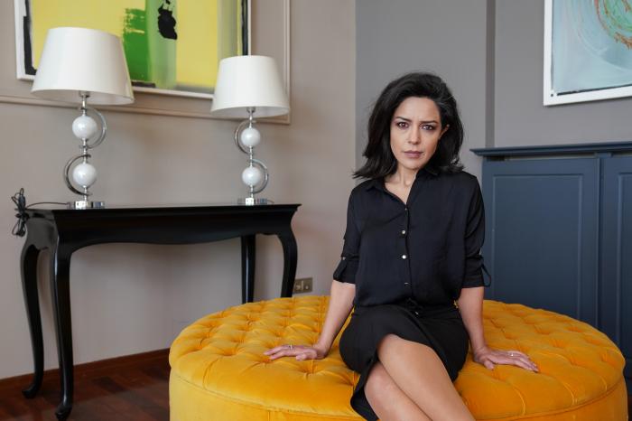 Gulay Ozdem poartă o fustă neagră și o cămașă de aceeași culoare