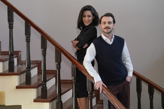 Gulay Ozdem poartă o ținută all-black și stă lângă Tolga Pancaroglu