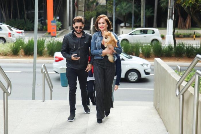 Gabriela Spanic poartă pantaloni lungi negri și are un cățel în brațe