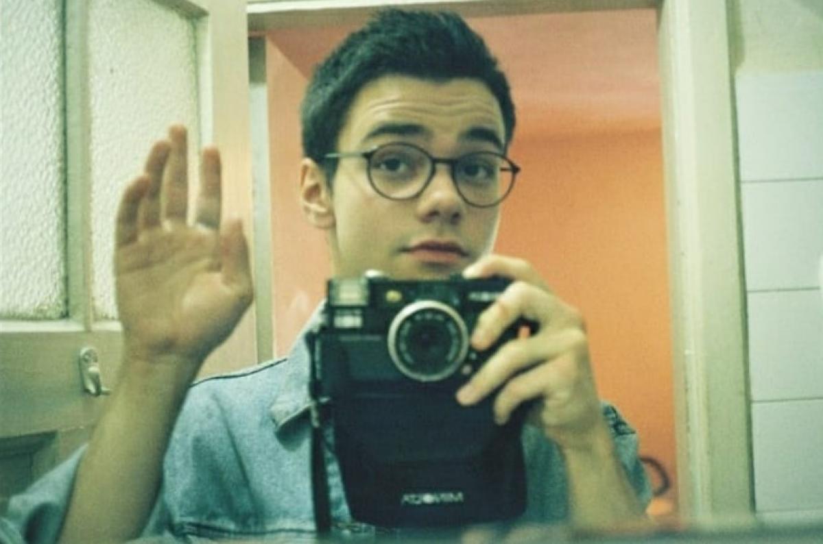 Bogdan Iancu poartă o cămașă albastră și ochelari