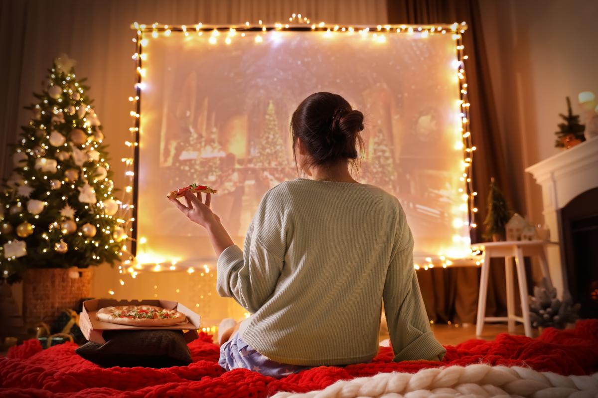fata din imagine este îmbrăcată într-o ținută lejeră și se uită la film