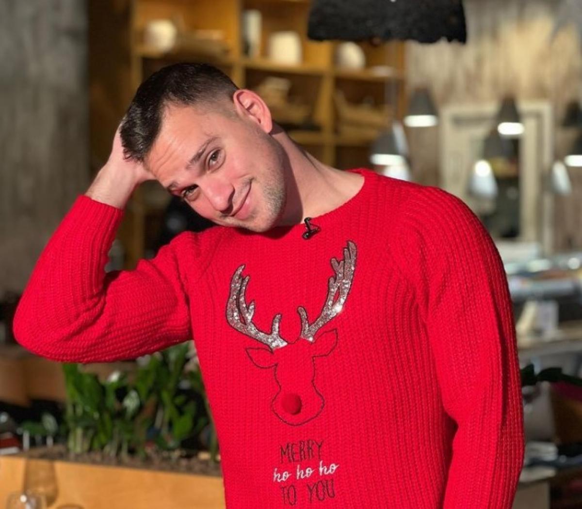 Vlad Gherman poartă un pulover cu tematică de Crăciun și zâmbește