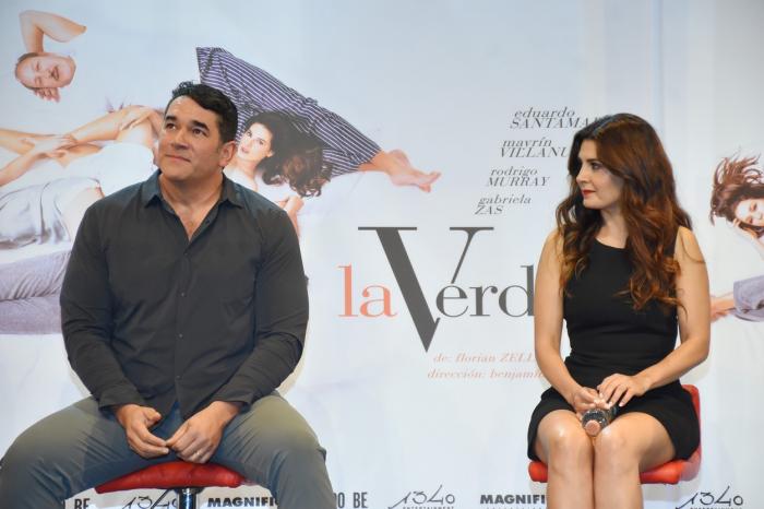 Eduardo Santamarina stă pe scaun și poartă blugi și o cămașă. Actrița Mayrín Villanueva stă pe scaun și poartă o rochie neagră