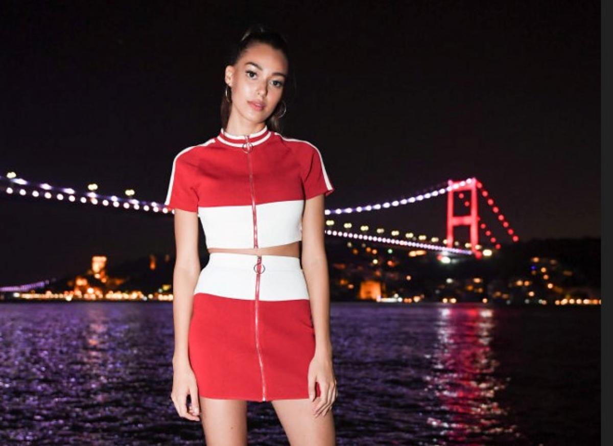 Dilan Cicek Deniz poartă o rochie scurtă și are părul prins în coadă de cal