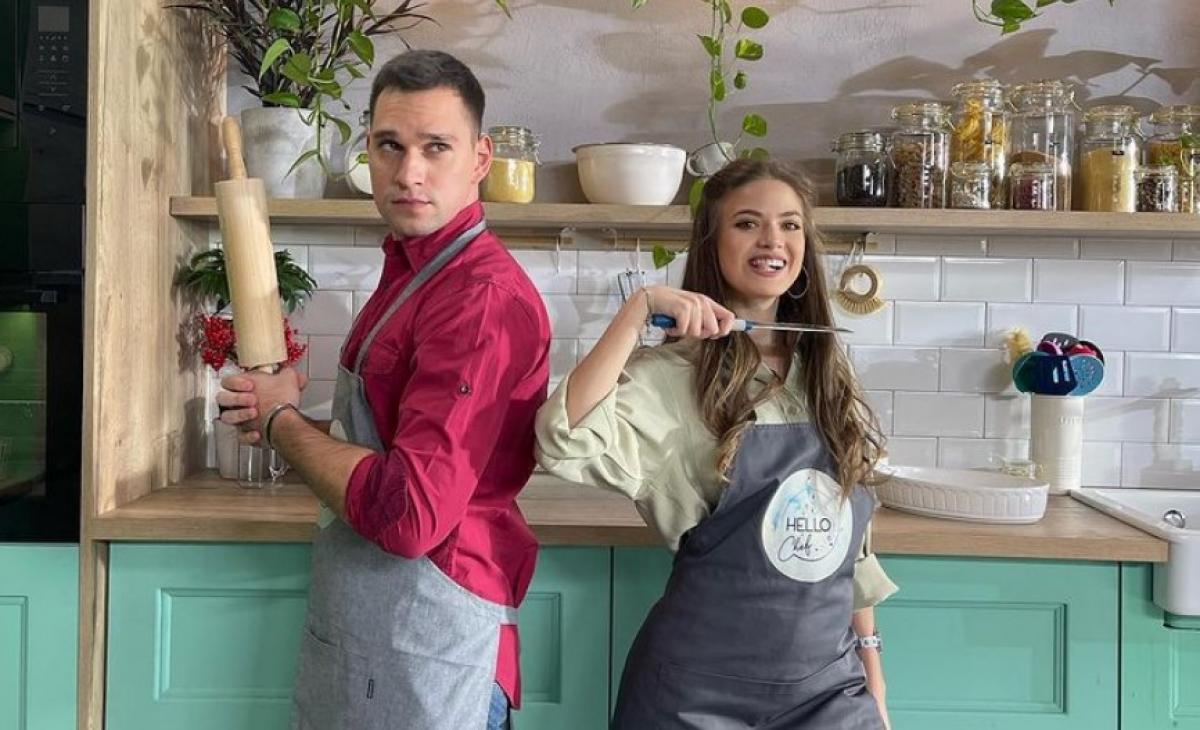 Vlad Gherman este îmbrăcat în blugi și o cămașă vișinie și are un șorț la brâu. Mara Oprea poartă de asemenea șorț