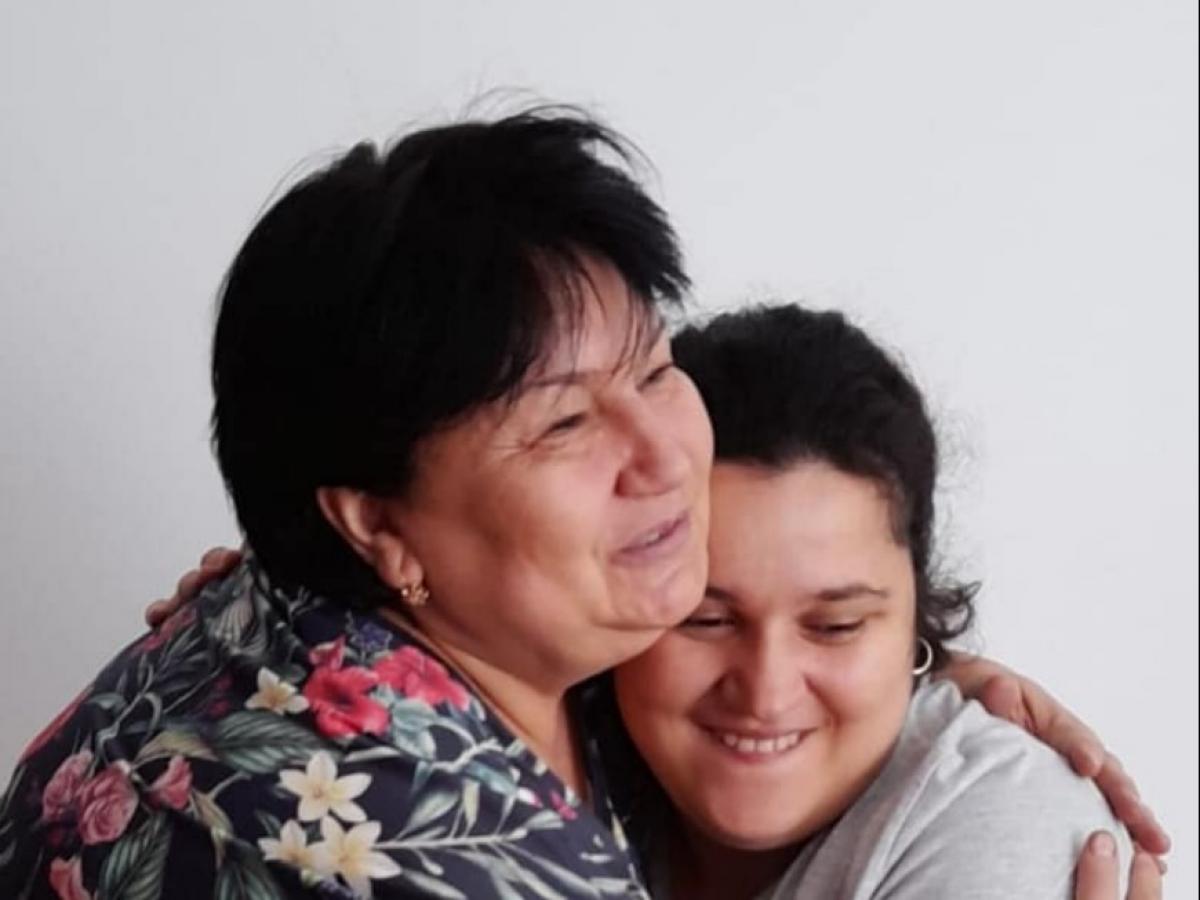 Mariana are părul scurt și poartă o bluză cu flori