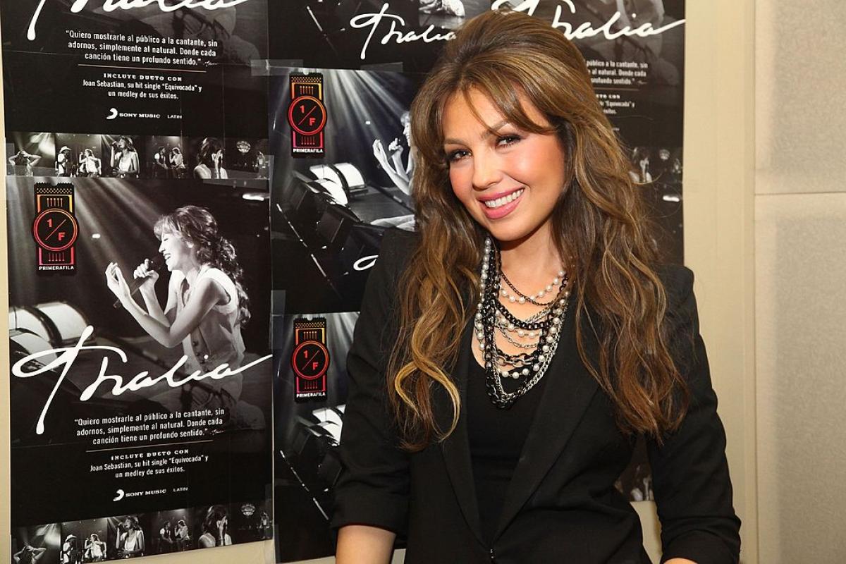 Thalia poartă o ținută all-black accesorizată cu mărgele alb-negru. Vedeta are părul desprins și ondulat