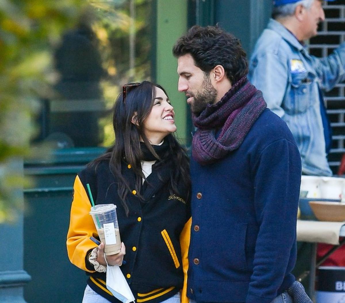 Eiza Gonzalez zâmbește spre iubitul ei și este îmbrăcată în blugi și hanorac larg