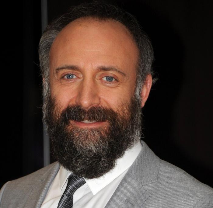 Portret al actorului  turc Halit Ergenç, îmbrăcat cu un costum gri