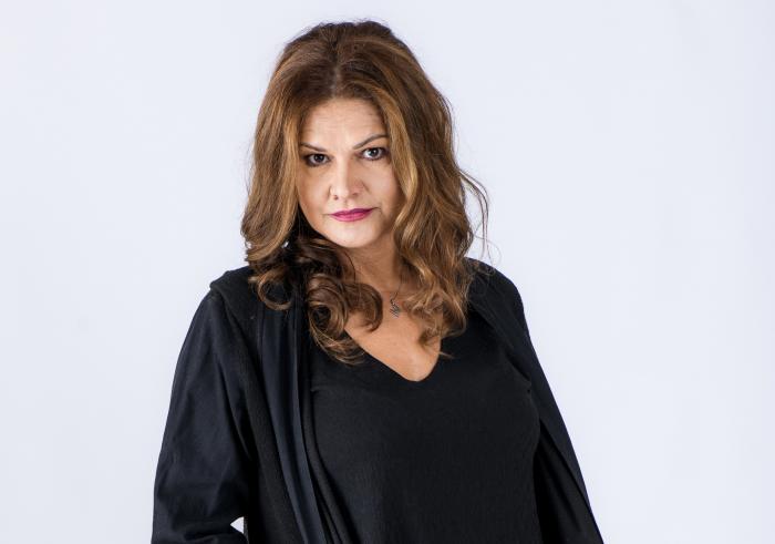 Actrița Maria Buză cu părul desfăcutl, fotografie de studio pe fundal alb, îmbrăcată în negru