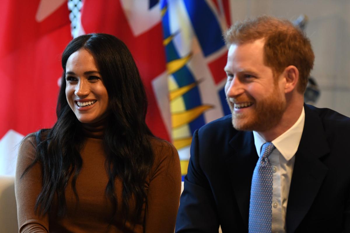 Meghan Markle și Priințul Harry zâmbitori, la o conferință