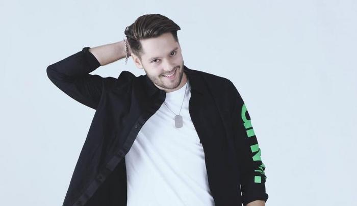 Actorul Vlad Vîlciu, fotografie de studio, îmbrăcat în trening negru