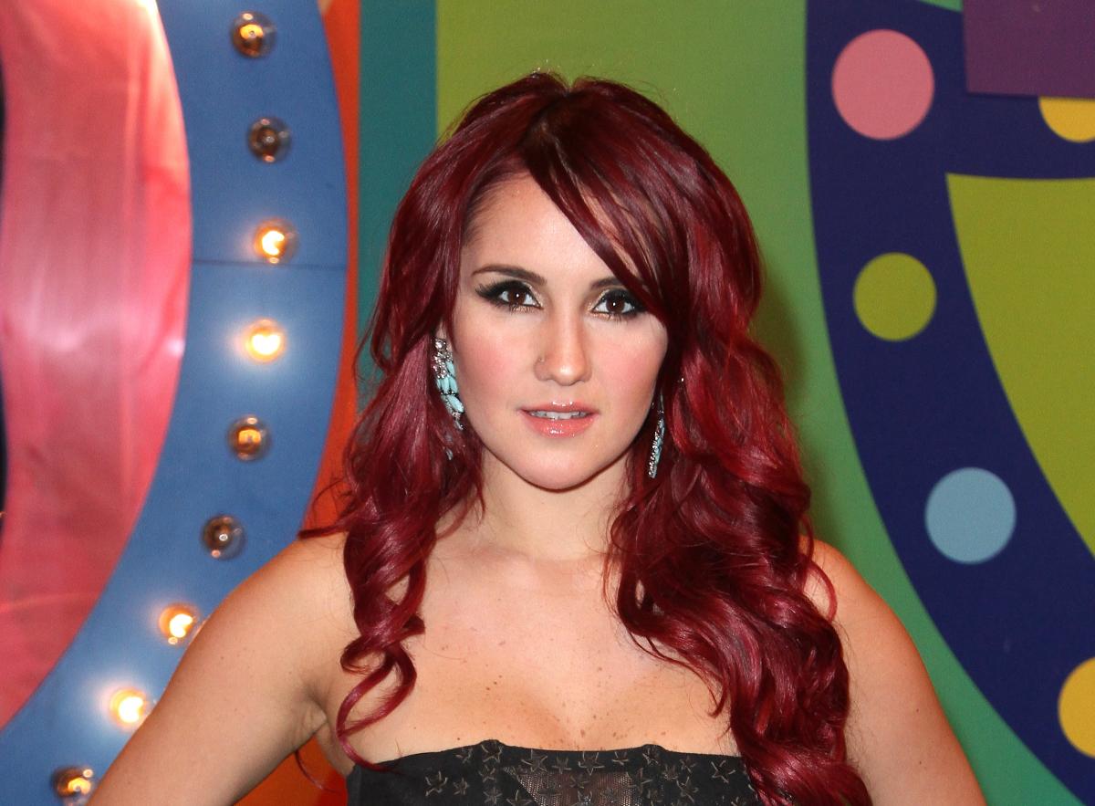 Actrița Dulce Maria, roșcată, pe un fundal multicolor