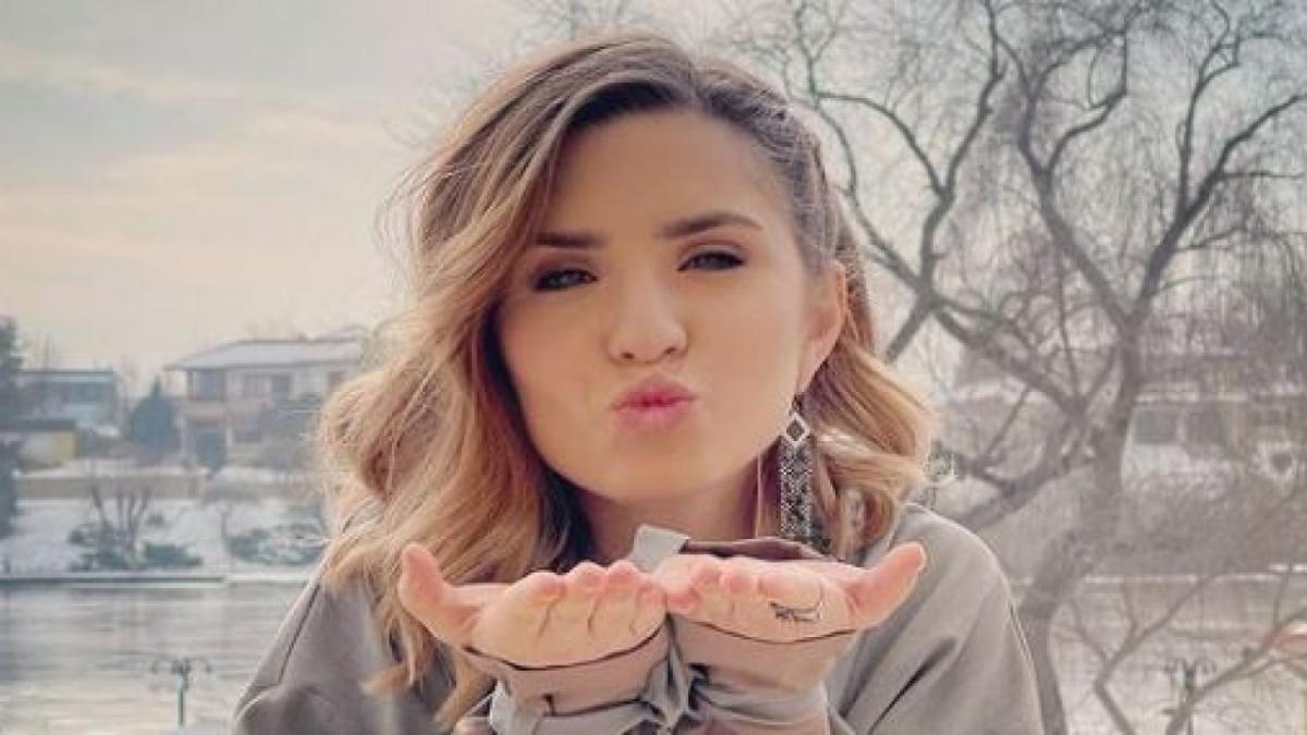 Cristina Ciobănașu, cu părul ondulat și tund bob, trimite pupici în direcția camerei de fotografiat.