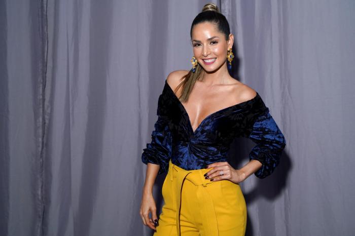 Carmen Villalobos îmbrăcată în pantaloni galbeni și o bluză cu decolteu