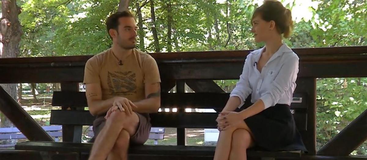 Conrad Mericoffer poartă pantaloni scurți și un tricou maro cu imprimeu