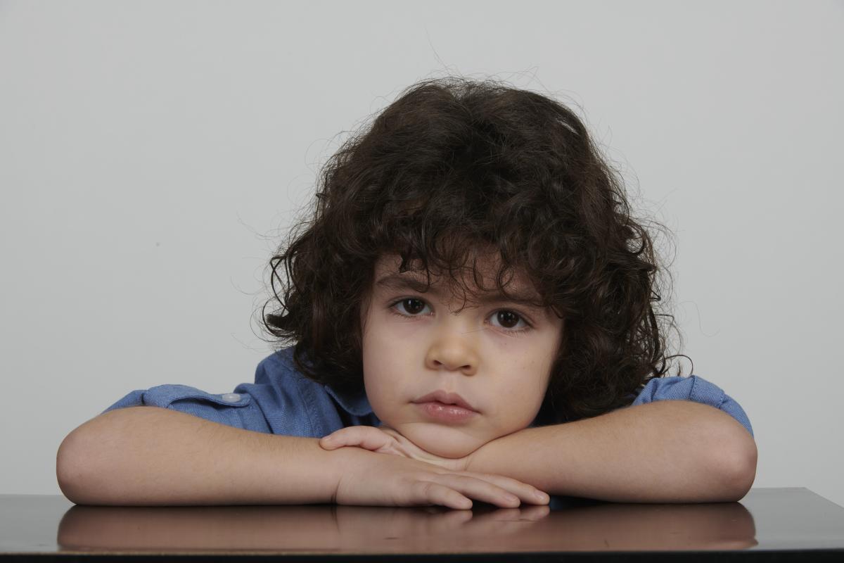 Berat Rüzgar Özkan are părul creț și o bluză albastră