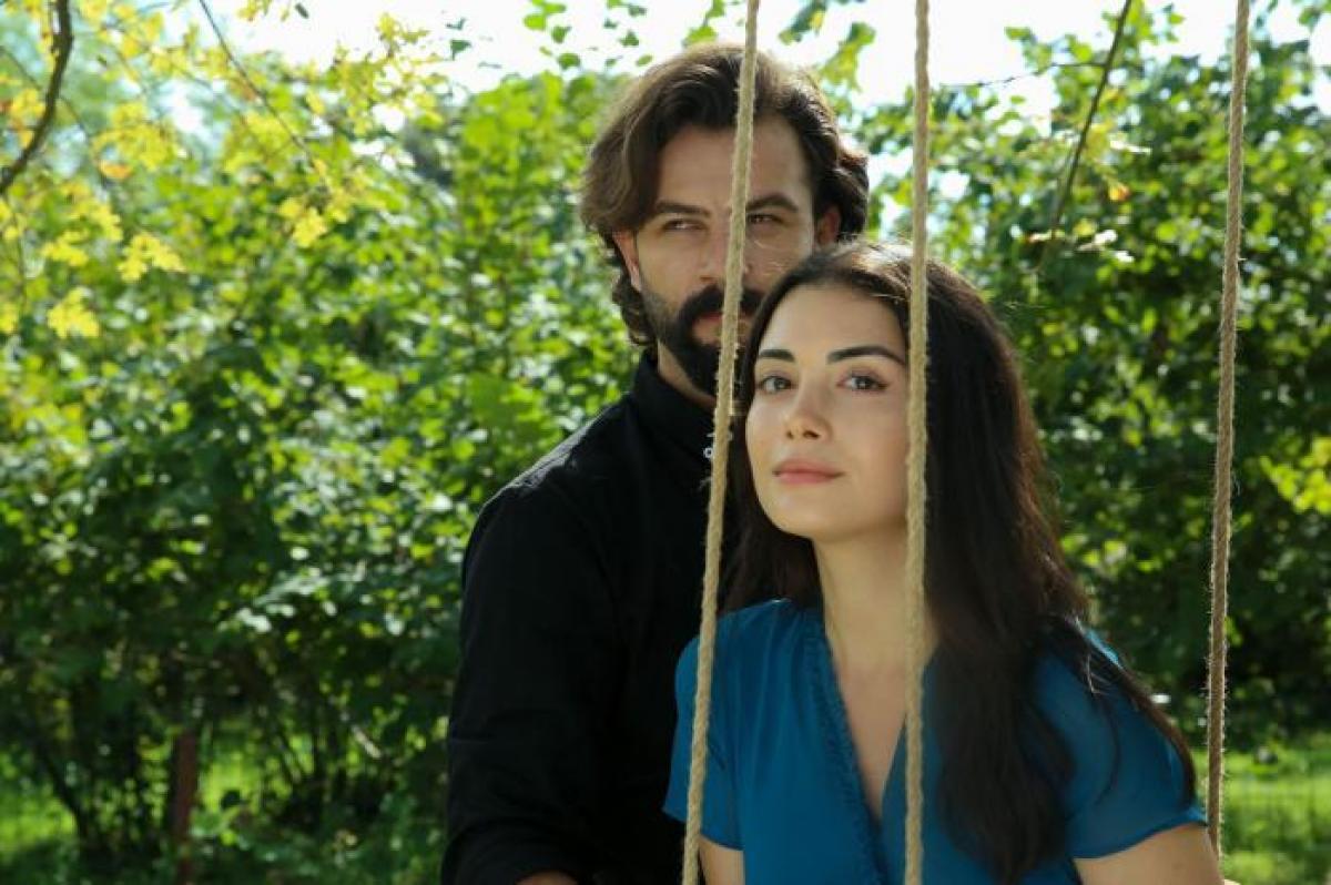 Özge Yağız poartă o rochie albastră și Gökberk Demirci are o ținută all-black