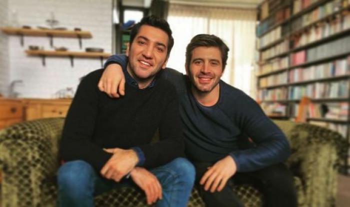 Cihangir Ceyhan este îmbrăcat în blugi închiși la culoare și pulover albastru închis