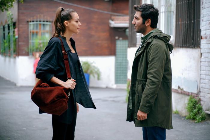 Berkay Ateş poartă o geacă lungă, verde