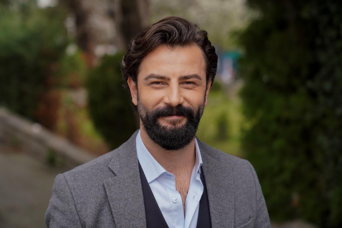 Gökberk Demirci poartă o cămașă albastră și un sacou gri