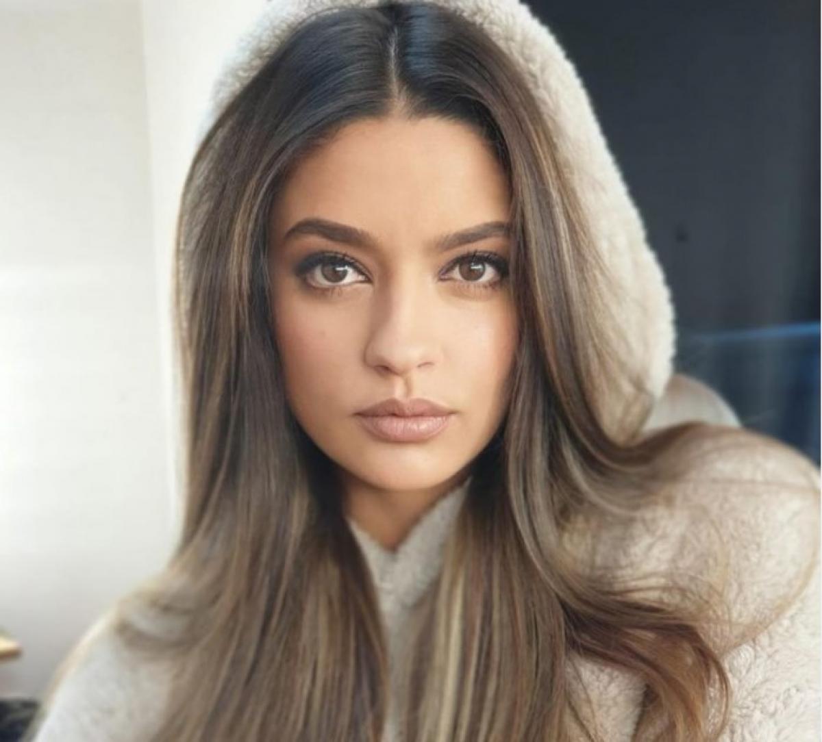 Oana Mosneagu poartă un hanorac cu glugă și are părul desprins