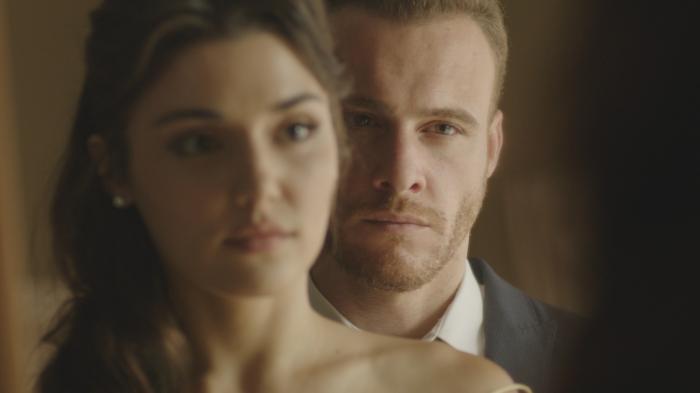 Serkan stă în spatele partenerei sale și amândoi se privesc în oglindă