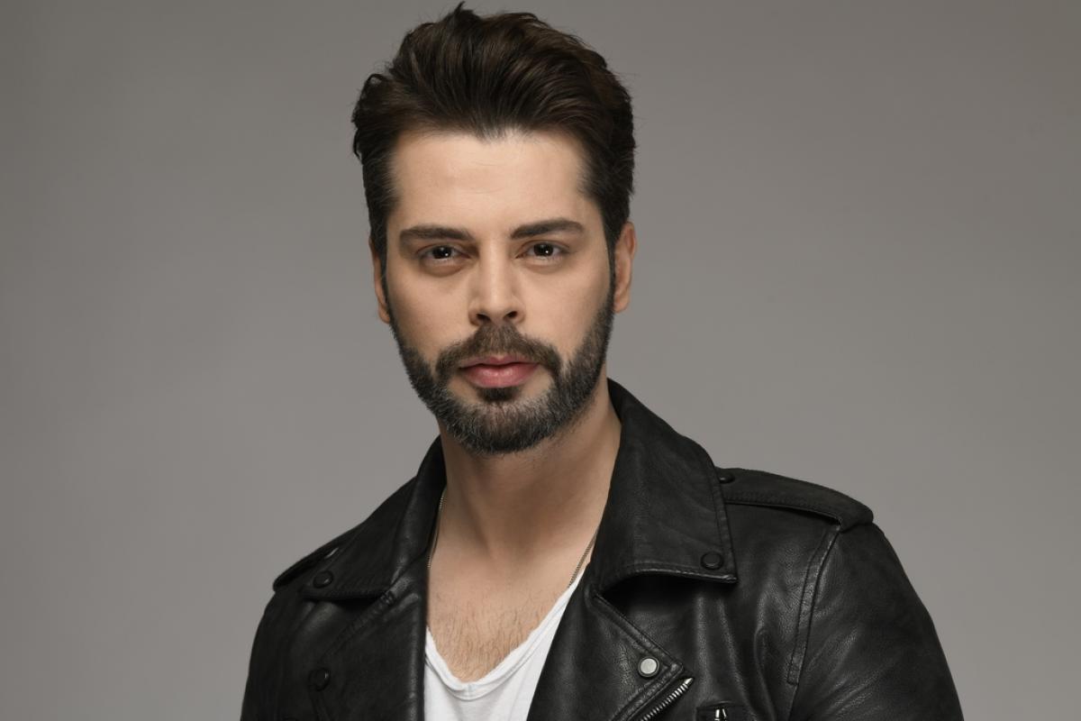 Ali Yasin Özegemen poartă un tricou alb și o geacă de piele neagră