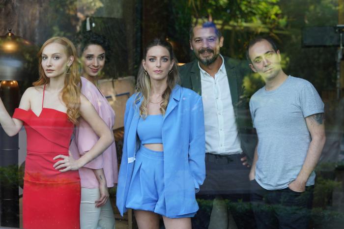 Sarp Bozkurt poartă un tricou albastru și stă alături de ceilalți colegi