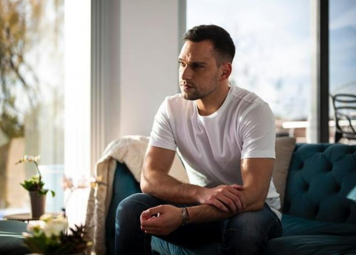 Vlad Gherman poartă un tricou alb și blugi