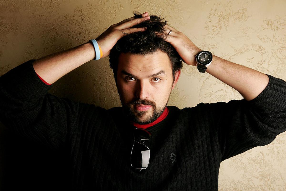 Fernando Rovzar poartă o bluză închisă la culoare și își pune mâinile pe cap