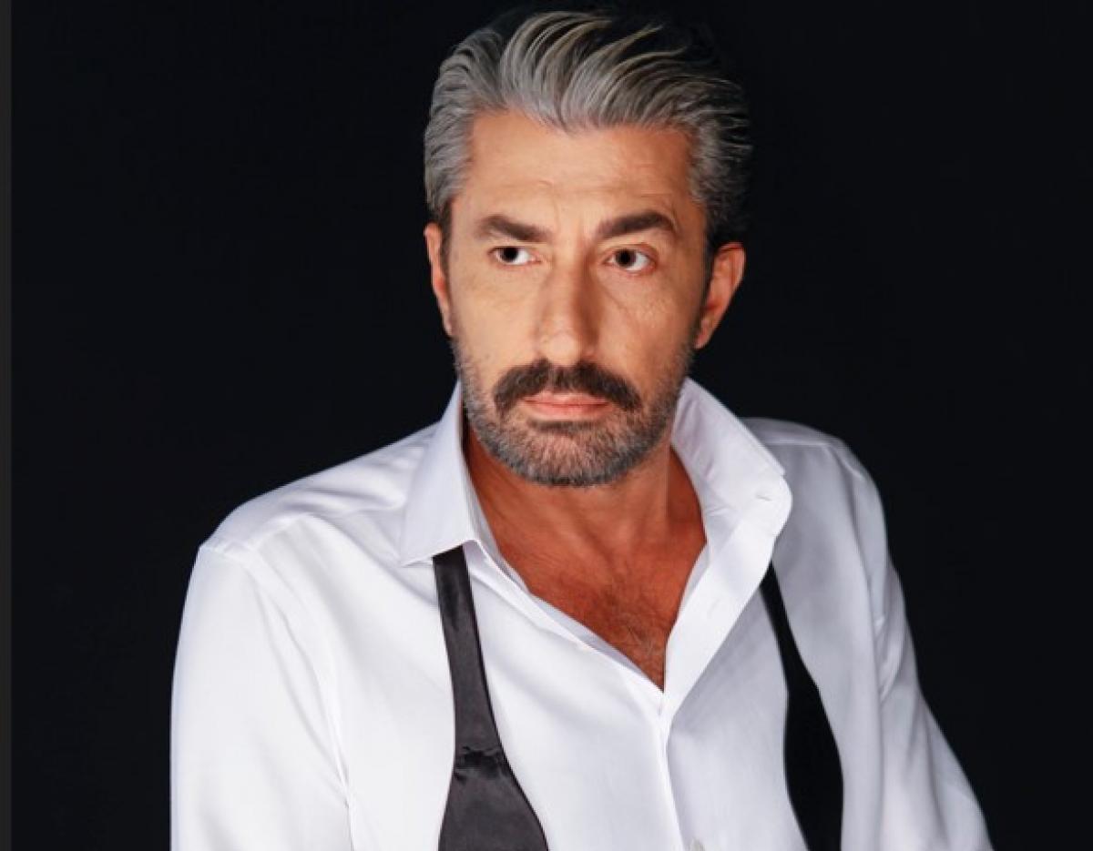 Erkan Petekkaya poartă o cămașă albă și un papion desfăcut