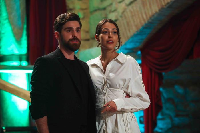 Dilan Cicek Deniz poartă o rochie albă cu mâneci lungi și are părul prins