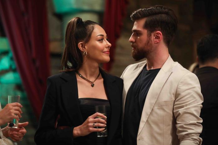 Dilan Cicek Deniz e îmbrăcată în negru și își privește partenerul de platou