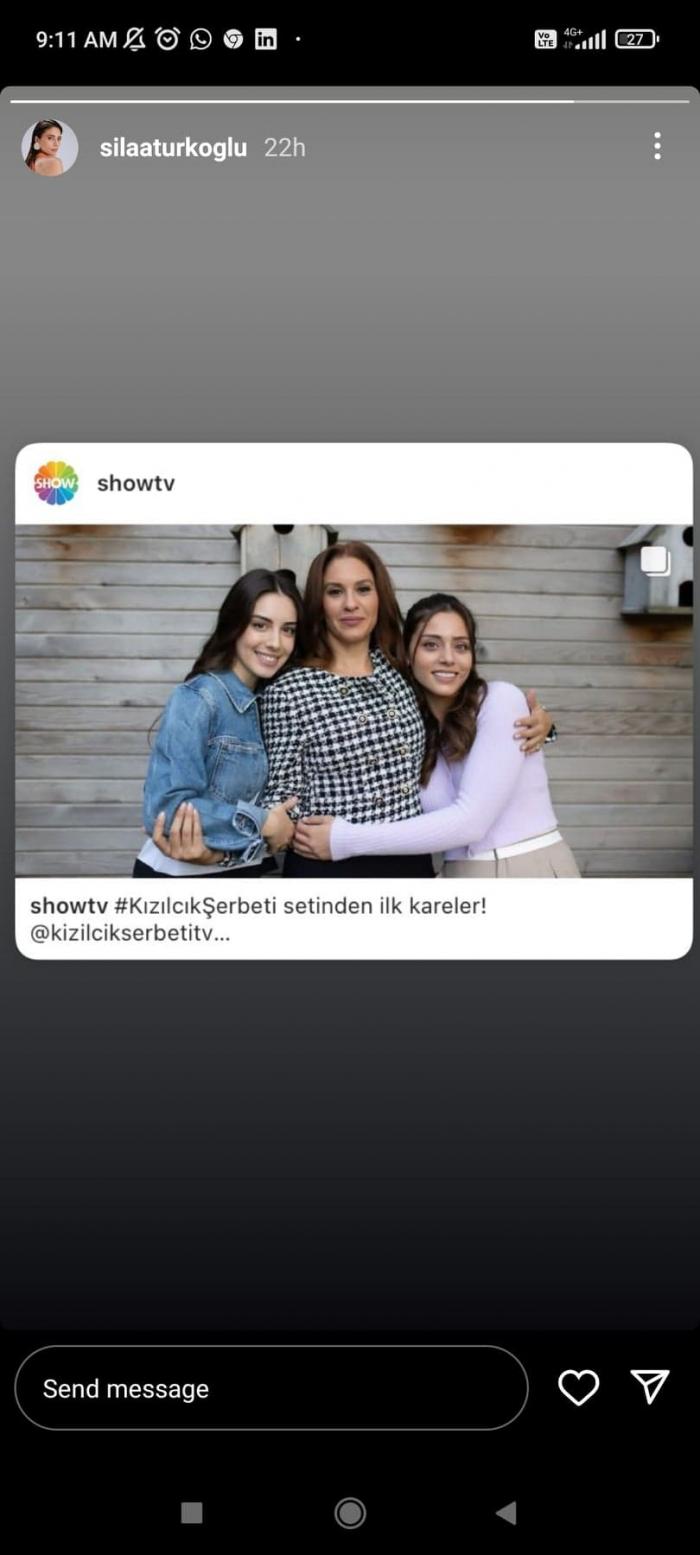 Sila Turkoglu poartă un pulover alb cu mâneci lungi și își îmbrățișează una din colege