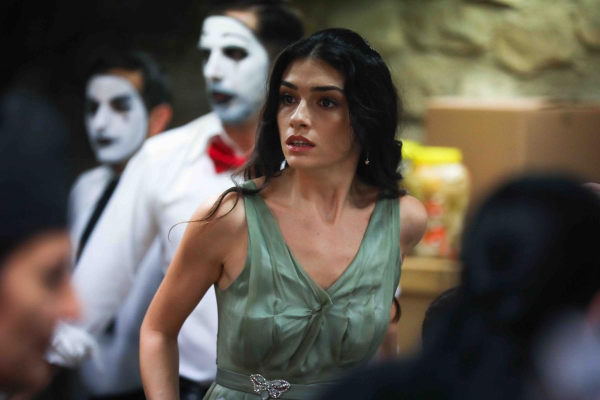 Hazar Ergüçlü poartă o rochie verde pal fără mâneci, are părul desprins și negru