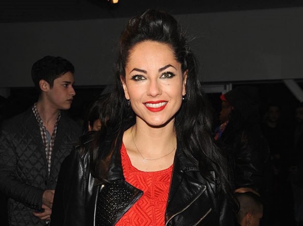 Bárbara Mori poartă o bluză roșie și o geacă de piele neagră și are părul desprins