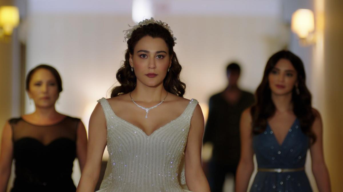 Merve Çağıran poartă o rochie de mireasă albă și are părul lung și ondulat