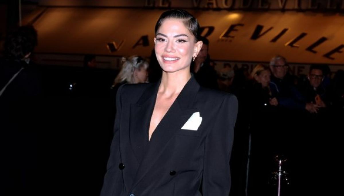 Demet Özdemir poartă un sacou negru și are părul prins în coc