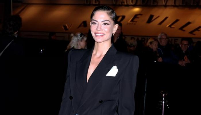 Demet Özdemir poartă un sacou negru și are părul prins în coc