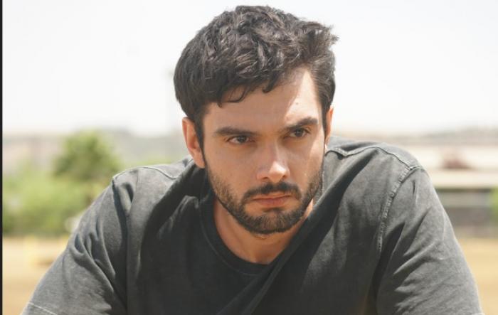 Toprak Can Adıgüzel poartă o bluză închisă la culoare