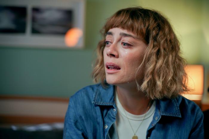 Demet Evgar poartă o bluză albă și o cămașă albastră și are părul scurt cu breton