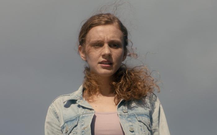 Ahsen Eroğlu poartă un tricou roz pal și o geacă de blugi deschisă la culoare