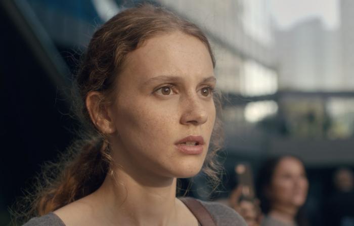 Ahsen Eroğlu poartă părul prins într-o coadă și are gura întredeschisă