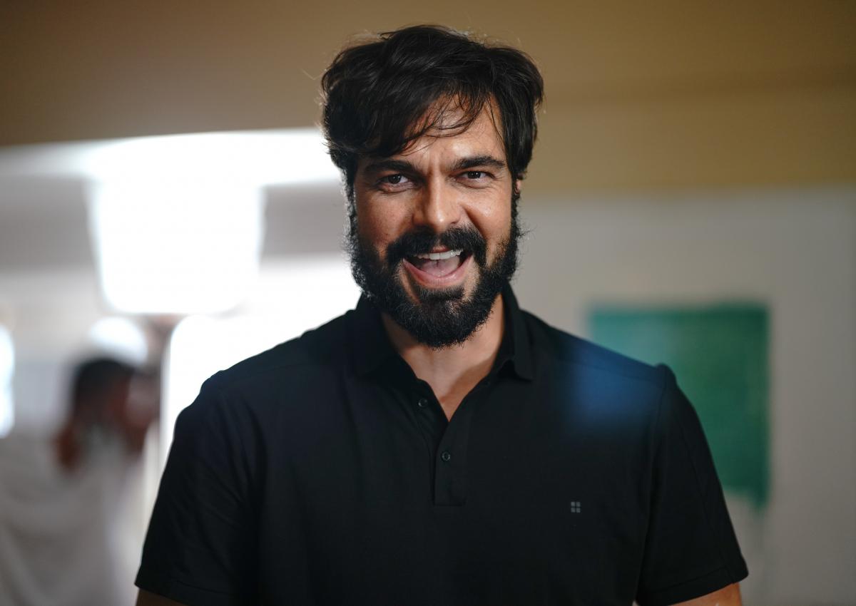 Halil İbrahim Ceyhan poartă o cămașă neagră și zâmbește