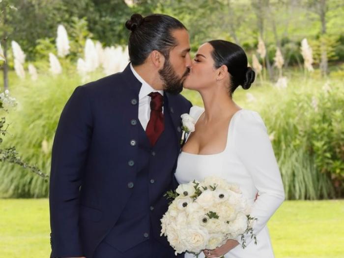 Maite Perroni poartă o rochie de mireasă albă și se sărută cu Andres Tovar care poartă un costum închis la culoare