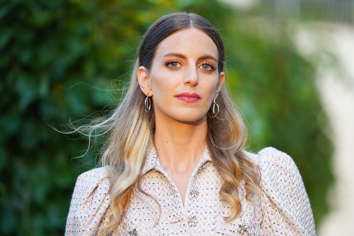 Bige Onal poartă o cămașă maro deschis și are părul lung și ondulat