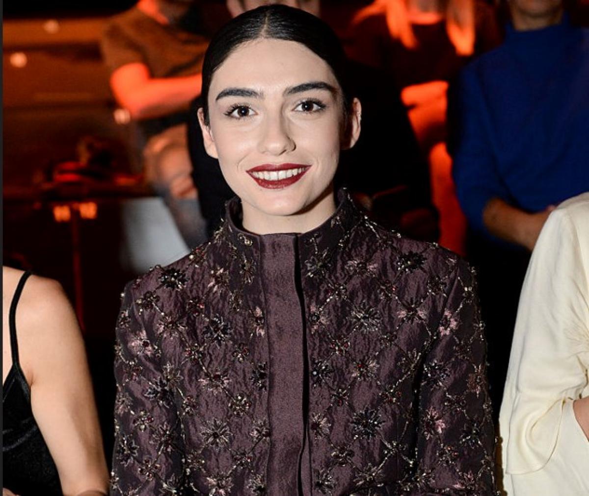 Hazar Erguclu poartă o rochie lungă cu imprimeu și un ruj închis la culoare