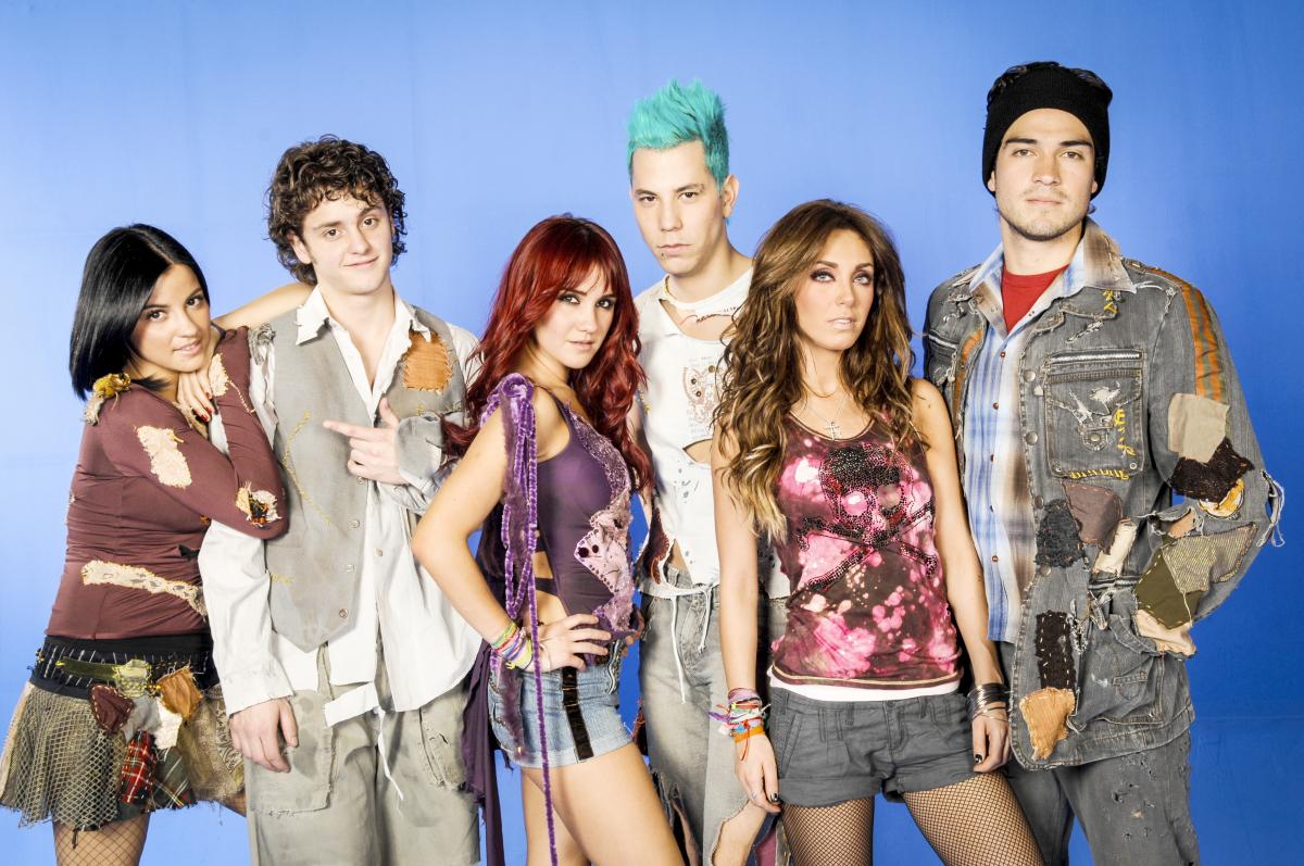 membrii formației RBD stau unul lângă celălalt și zâmbesc în fața camerei